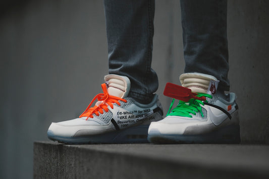 person wearing white-green-and-orange sneakers