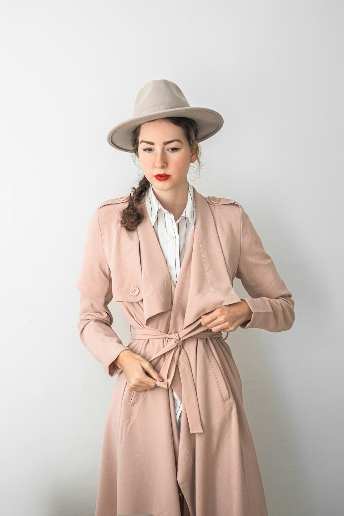 a woman wearing a trench coat and hat