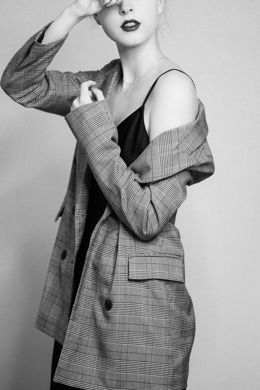 a woman in a blazer poses for a black and white photo