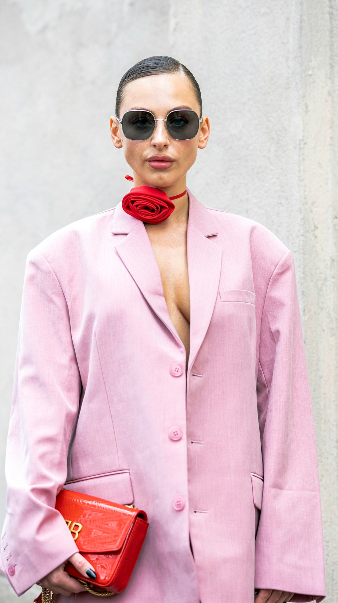 a woman wearing a pink suit and sunglasses